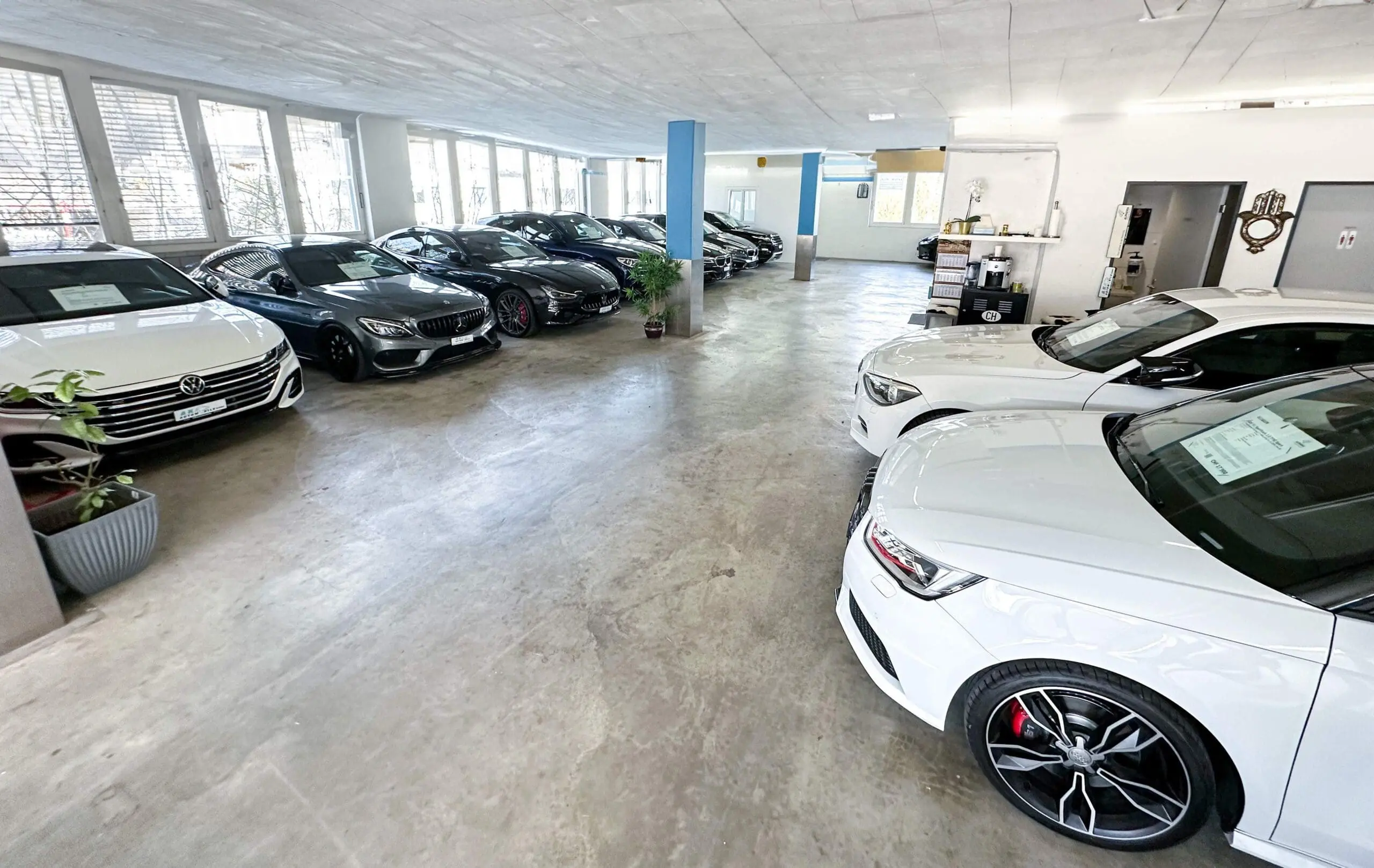 Ein Autohaus-Showroom mit einer Auswahl an hochwertigen, geparkten Autos.